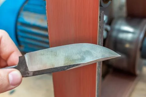 Grinding polishing sharpening knife blade on the belt grinder sander equipmen Stock Photos