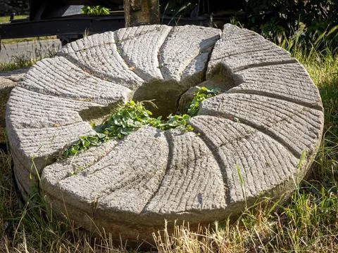 Grinding stone from an old windmill, broken in two pieces. Sobotka, Poland. Stockfoto's