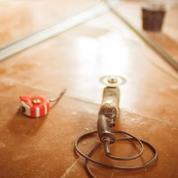 Grinding tool with abrasive cutting disc on the dirty brown floor Stock Photos