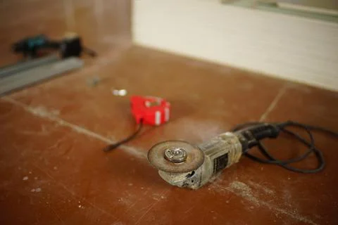 Grinding tool with abrasive cutting disc and other tools on the dirty brown f 库存照片