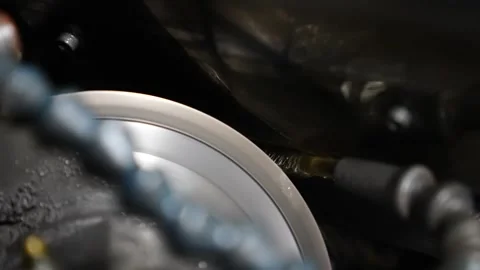 Grinding wheel spraying coolant while sharpening a circular metal disc component 動画素材 345941640