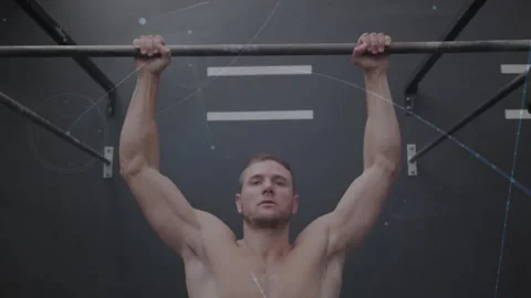 Gripping bar, shirtless man doing pull-ups on rig for fitness, light flares Stock Footage 330917501