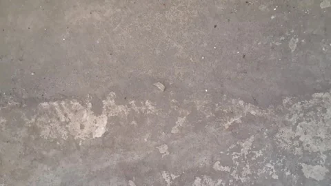 Gritty concrete ground surface texture captured in raw motion video footage Video stock 337844129
