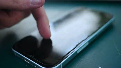 Gritty Crime Documentary Filler - Man Scrolls on Old Cracked Smartphone Video stock 336035599