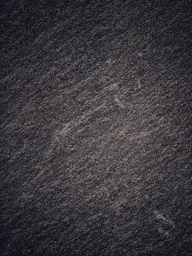 Gritty, dark texture with mottled surface covers the frame, creating a dramat Stock Photos