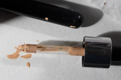 Gritty overhead close-up of two used makeup items: concealer wand and tube, r Stock Photos