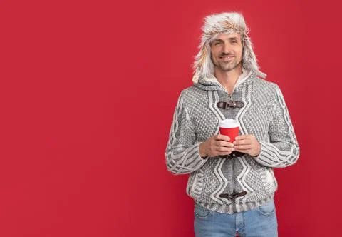Grizzled guy in hat on red background. hoary man drinking coffee. Foto stock
