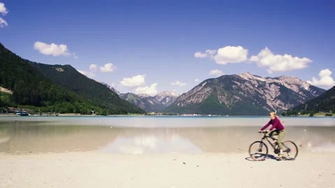 Grl riding a bicycle on a sandy beach. Stock Footage 90447153
