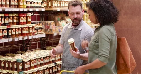 Grocer advising customer in store Stock Footage 73519500