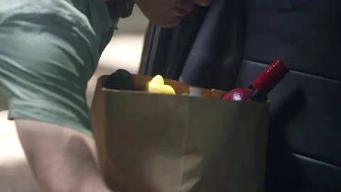 A grocery delivery driver grabs a bag of food out of the car Video stock 153239581