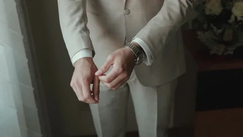 Groom adjusting cuff of beige wedding suit Video stock 317139982