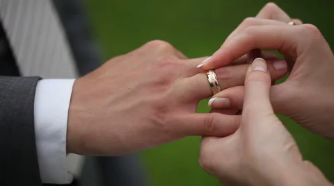 The groom and the bride dress each other wedding rings. Close up macro lens Stock Footage