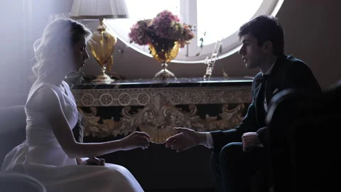 Groom and bride join hand sitting in armchairs near table Stock Footage 145716620