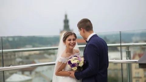 Groom and bride standing in front of the old city landscape on the rooftop Stock Footage 73781916
