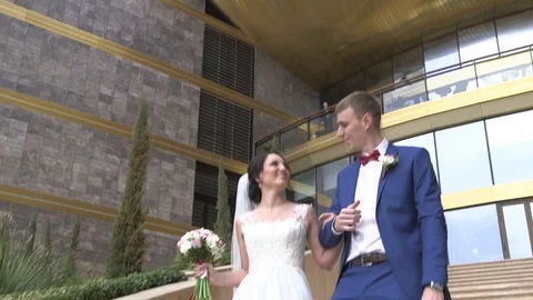 Groom and bride walking down the stairs on the luxury hotel territory Stock Footage 94216682