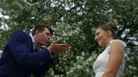 Groom blows up confetti to the bride Stock Footage 61783362