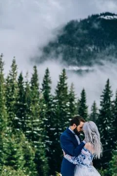 Groom in a blue suit and bride in white in the mountains Carpathians Stock Photos