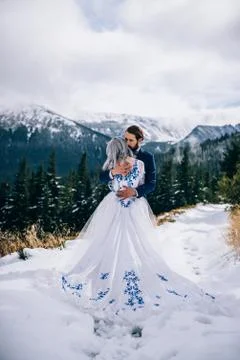 Groom in a blue suit and bride in white in the mountains Carpathians Foto stock
