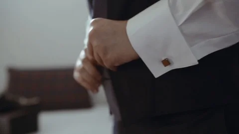 Groom buttoning up and arranging the vest before the wedding. Stock Footage 93420319