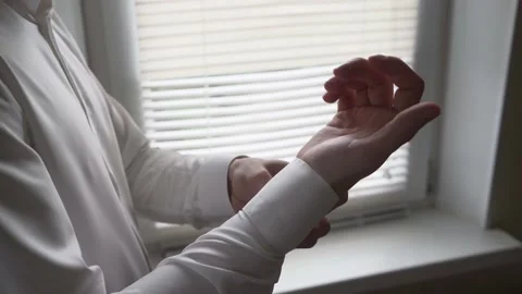 The groom is buttoning his buttons of white shirt before the wedding ceremony 動画素材 166383734