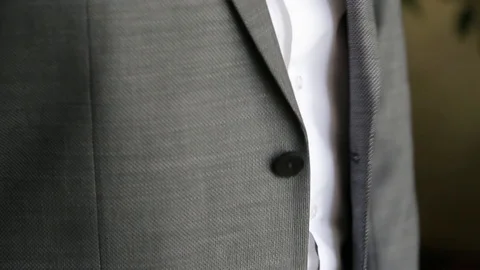 Groom is buttoning a jacket. Stylish man in a suit fastening buttons on his Stock Footage 92862708
