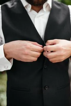 The groom buttons his jacket with friends Stock Photos