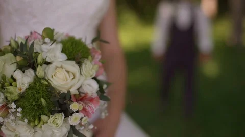 Groom comes to charming blonde bride with bouquet behind her. Slow motion Stock Footage 107781768