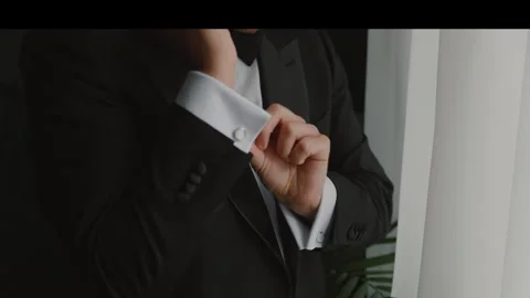 Groom dressed in a black jacket adjusts his cufflinks Stock Footage 309534853
