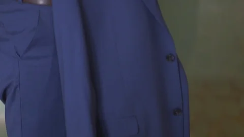 Groom gettin dark-blue jacket on preparing for the wedding in hotel suite Stock Footage 94213008