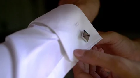 Groom getting his cuff link done. White female with beautiful nails Stockbeeldmateriaal 97661425