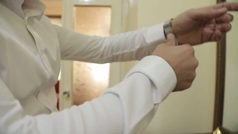 The groom is getting ready for the wedding, wearing clothes and accessories  Video stock 315414226