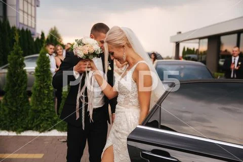 Groom helps bride get out the car. Wedding day Stock Photos
