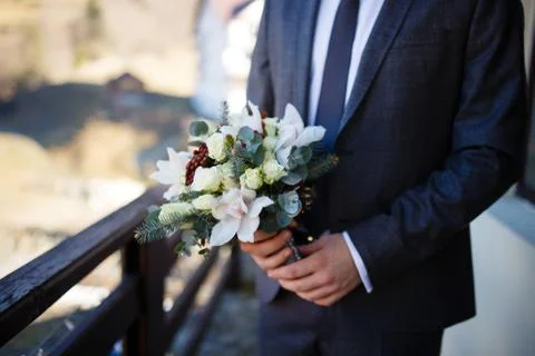 Groom holding bridal bouquet Stock Photos