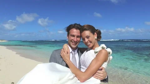 Groom holding bride in arms at the beach, turning around Vidéo 59187165