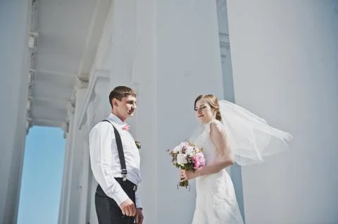 The groom hugging the bride with the white columns 3885. Stock Photos