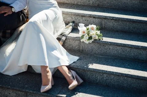 Groom hugs bride tender while wind blows her veil Stock Photos