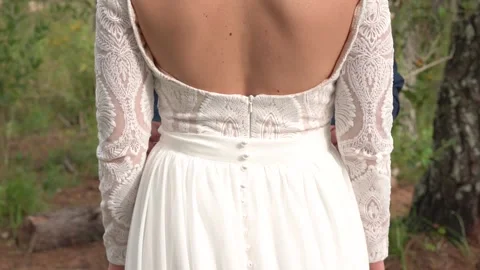 Groom interlocking fingers while hugging bride Stock Footage 157499051