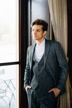 Groom leaned against the frame of the large window of the old villa. Lake Como 스톡 사진
