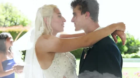 Groom lifting bride with wedding veil, couple embracing for kiss, cloud wash Stock Footage 331193399