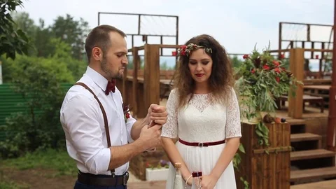 The groom opens the bottle with sand. Wedding tradition sand mix. Stock Footage 69889054