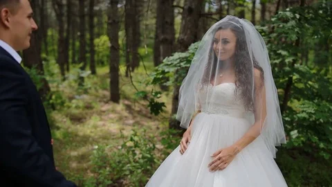 Groom opens the face of the bride raising her veil Stock Footage 71083714