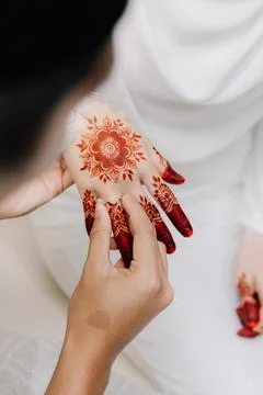 Groom Placing Diamond Ring on Bride's Hennaed Hand. Stock Photos