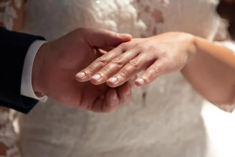 Groom placing wedding ring on bride's finger Stock-Fotos