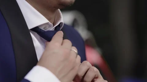 Groom preparing his formal attire by adjusting a blue tie Vídeo Stock 336076890