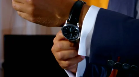 The groom puts his hand on the clock Stock Footage 58054100
