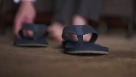 Groom puts on a pair of navy blue slippers before the wedding ceremony. Stock Footage 135234516