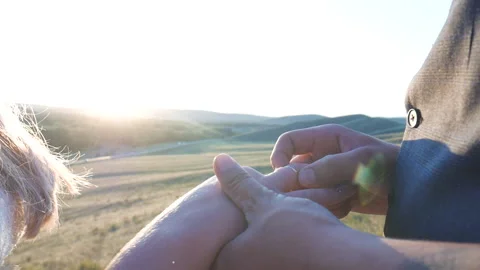 The groom puts the ring on the bride on the background of sunset and mountains Vídeo Stock 144992369