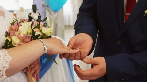 The groom puts the ring on the bride Stock Footage 106358185