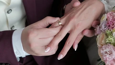 The groom puts the ring on the bride Stock Footage 136143553