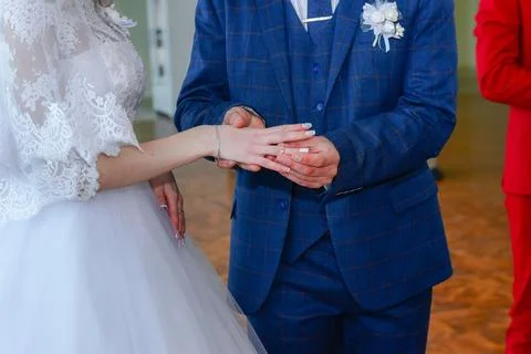 The groom puts a ring on the bride. Stock Photos